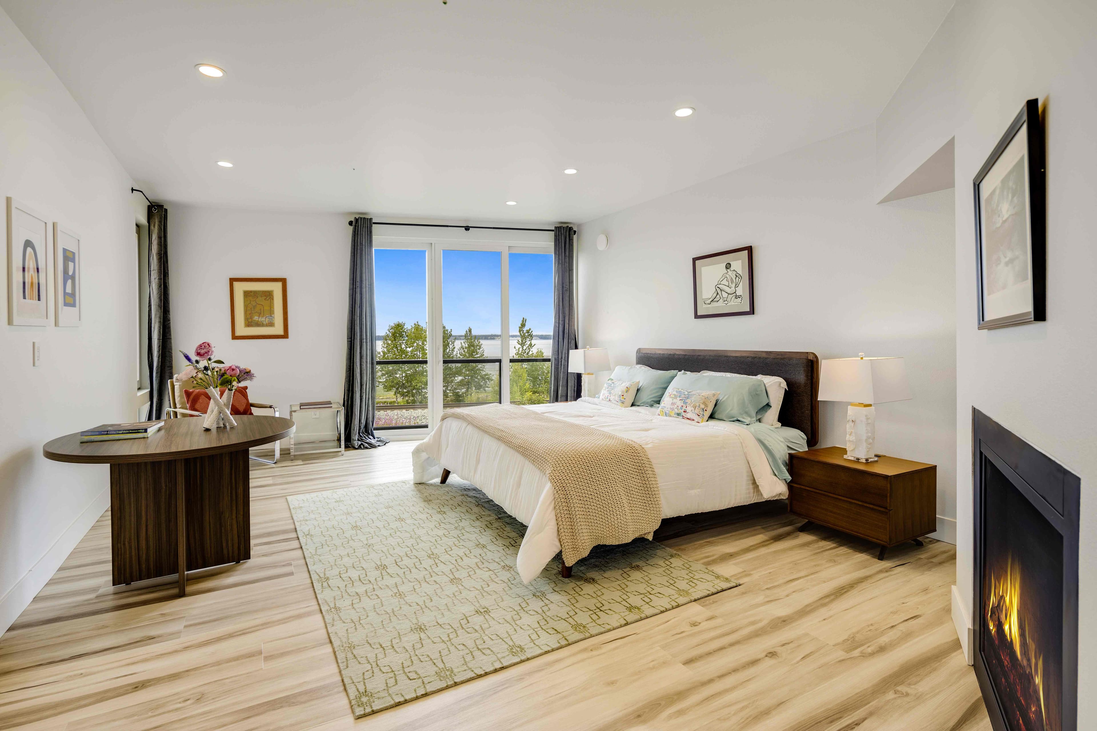 Master bedroom with floor-to-ceiling Cook Inlet views and gas fireplace, Villa at Bootleggers Landing Alaska luxury villa