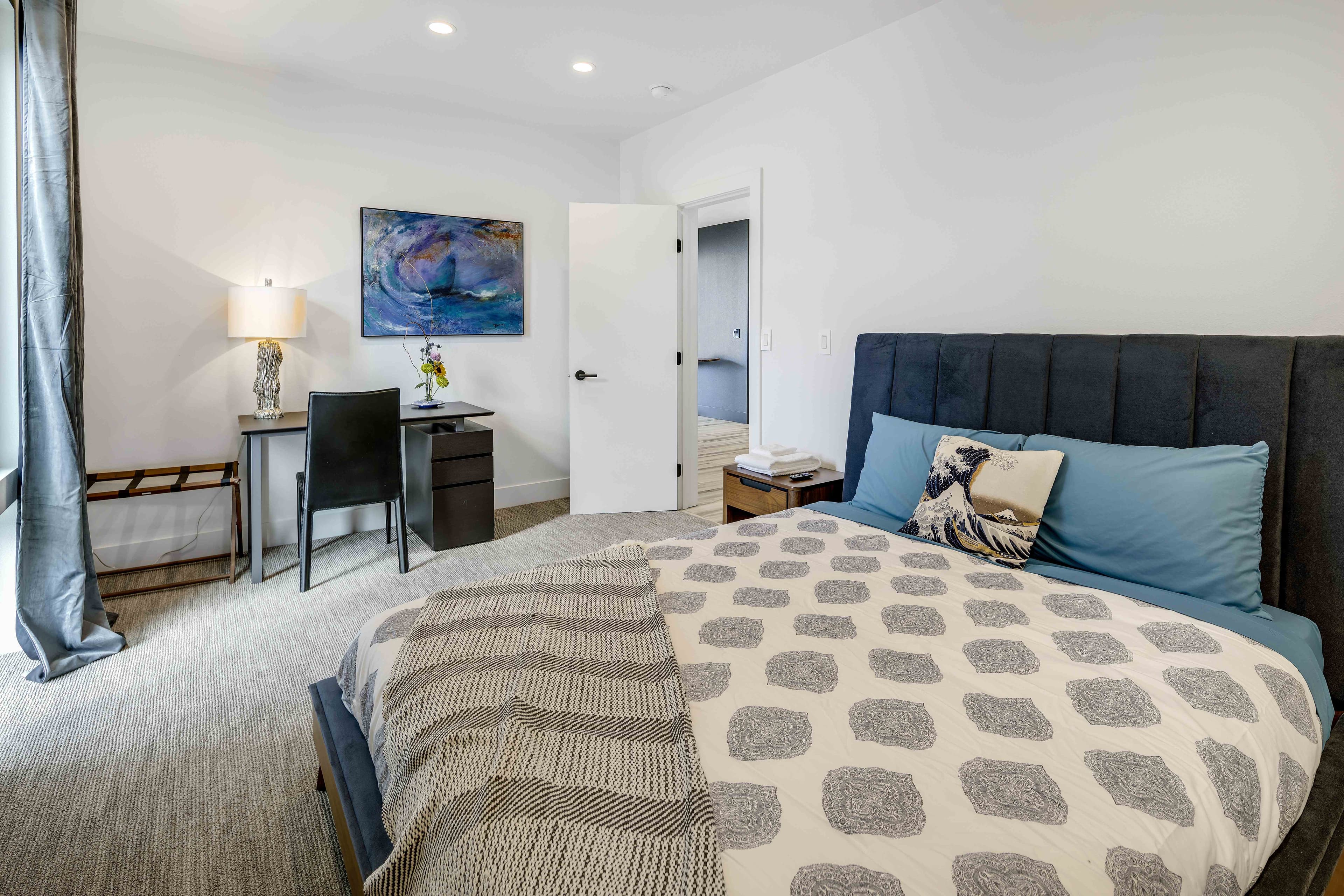 Second bedroom with king bed, writing desk, and ocean-inspired artwork, Alaska luxury rental