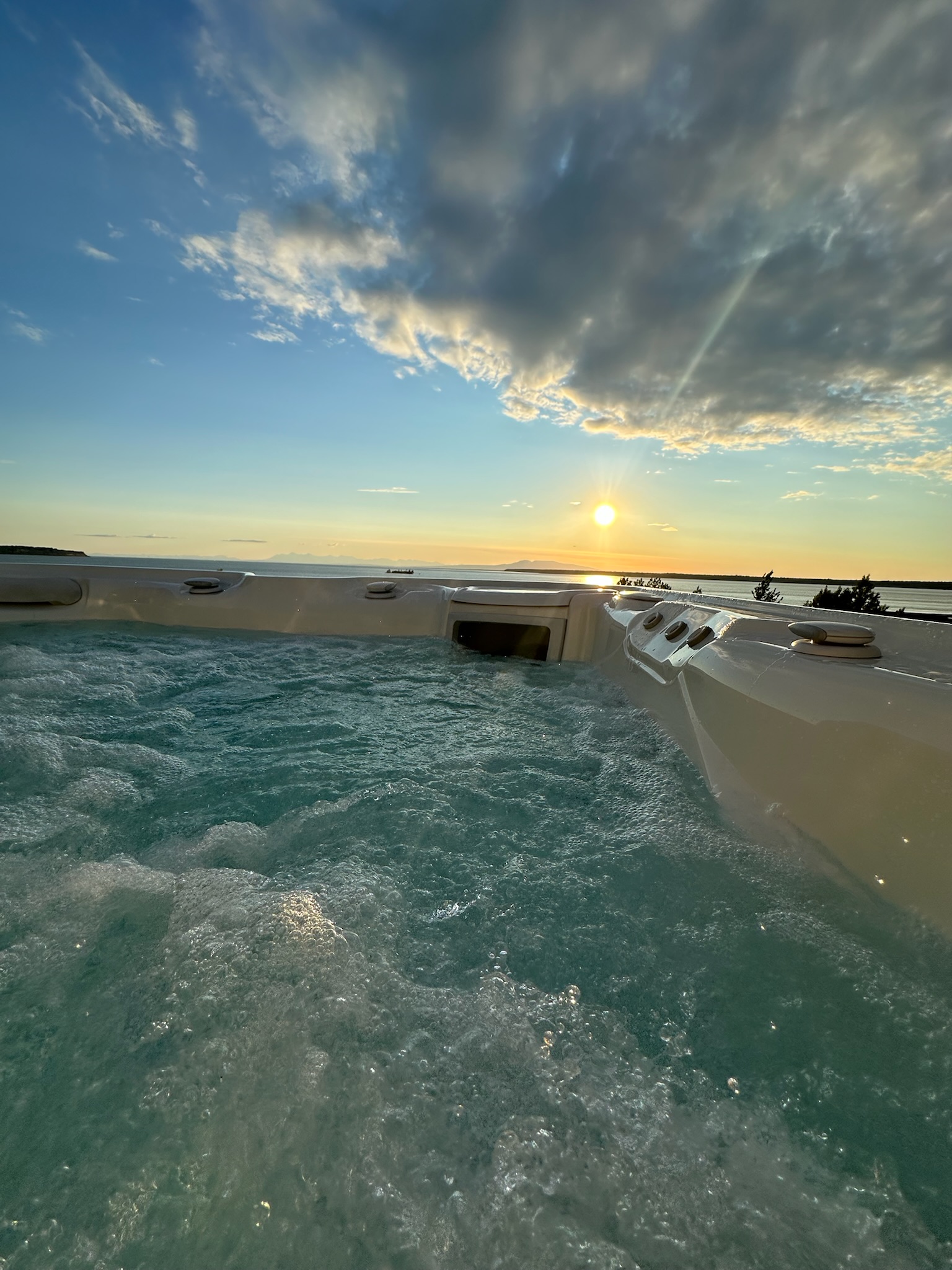 Sunset over Cook Inlet from rooftop hot tub deck, Villa at Bootleggers Landing Anchorage Alaska luxury rental